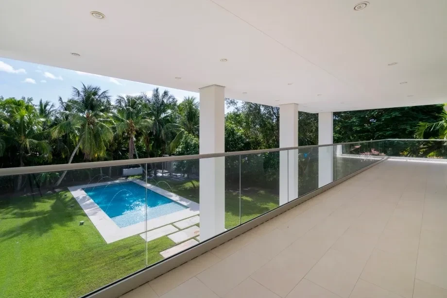 Luxury home balcony overlooking pool and tropical landscaping